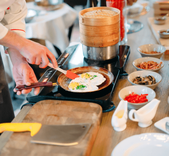 person cooking eggs on an induction plate